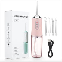 Pink oral irrigator with packaging, cleaning brushes, and USB cable on a white background